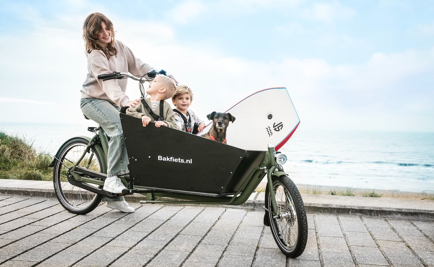 Moeder met kinderen op een Bakfiets.nl CargoBike – originele Nederlandse bakfiets aan zee